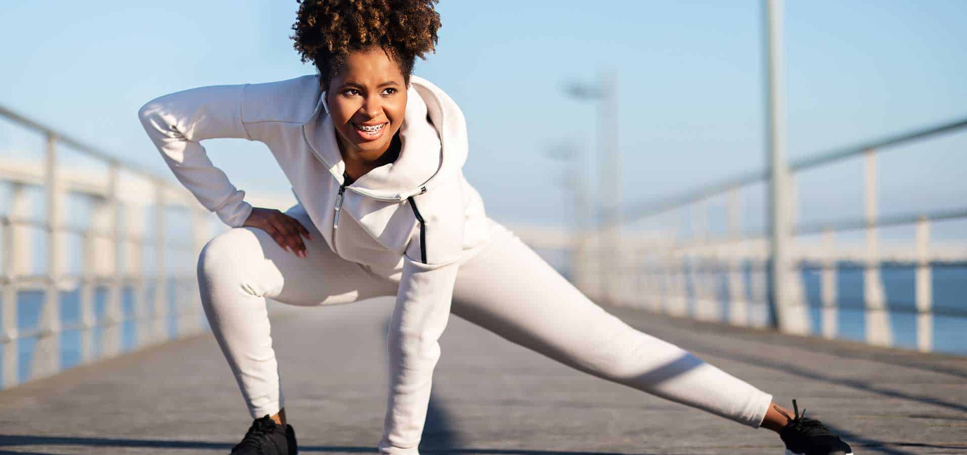active training motivated young black female athlete stretching leg muscles before jogging active training motivated young black female athlete stretching leg muscles before jogging